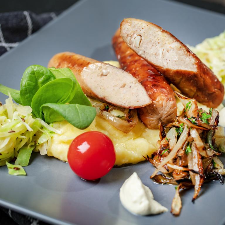 Spitzkohl mit Kartoffelstampf, Schmorrzwiebeln und vegetarischer Bratwurst